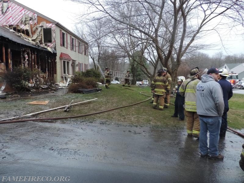 Crews begin to take up equipment after successfully extinguishing garage fire. PHOTO BY: Travis Tiffany